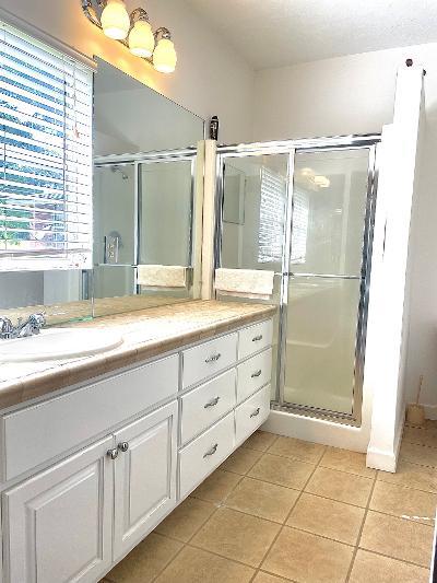 bathroom featuring tile patterned flooring, vanity, and a shower with shower door