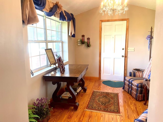 entrance foyer with lofted ceiling, light hardwood / wood-style flooring, and a chandelier