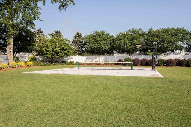 view of community with community basketball court, a yard, and fence