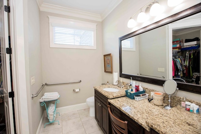 bathroom featuring crown molding, toilet, vanity, baseboards, and tile patterned floors