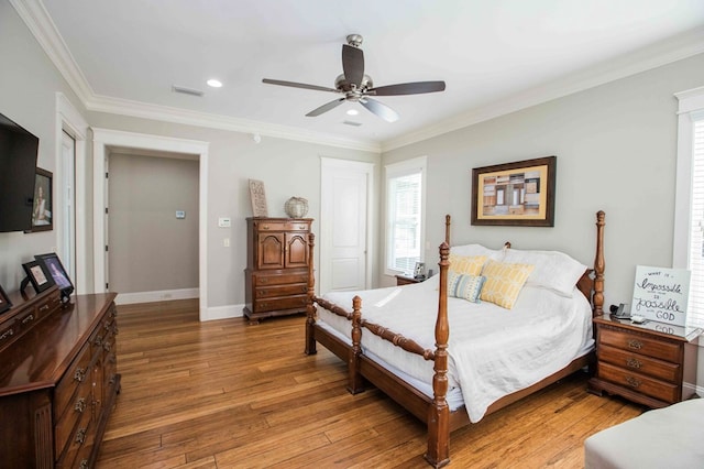 bedroom with baseboards, visible vents, a ceiling fan, crown molding, and light wood-style floors