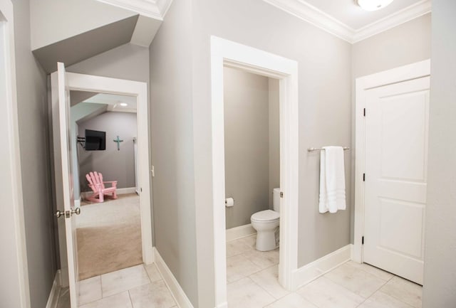 bathroom featuring tile patterned flooring, baseboards, crown molding, and toilet