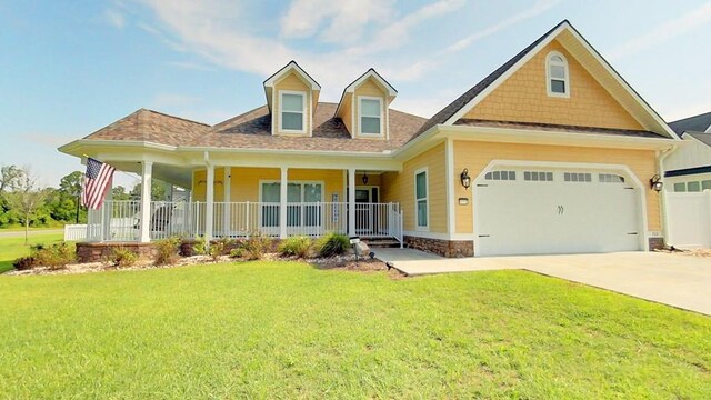 view of front of property with a porch, a garage, and a front yard