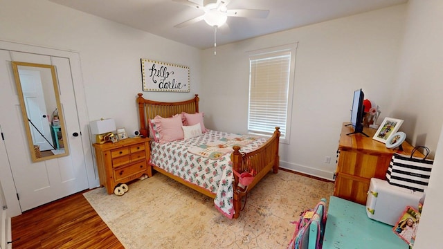 bedroom with baseboards, wood finished floors, and a ceiling fan