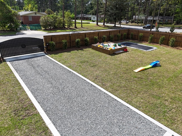 view of home's community with a gate, fence, a vegetable garden, and a yard