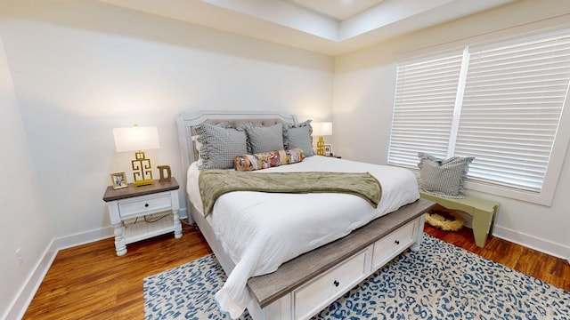 bedroom with baseboards and wood finished floors