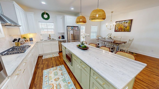 kitchen featuring green cabinets, white cabinetry, stainless steel appliances, and a center island