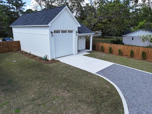 detached garage with fence and concrete driveway