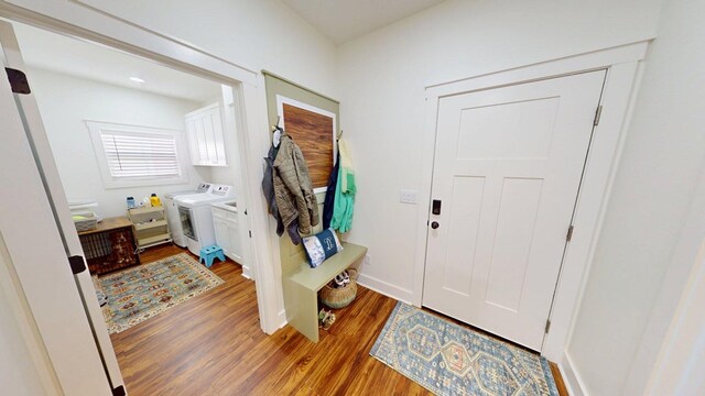entrance foyer with baseboards, washing machine and dryer, and light wood-style floors