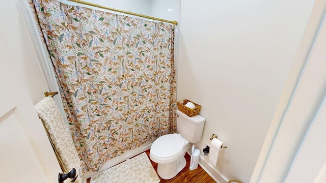 full bath featuring toilet, curtained shower, and wood finished floors