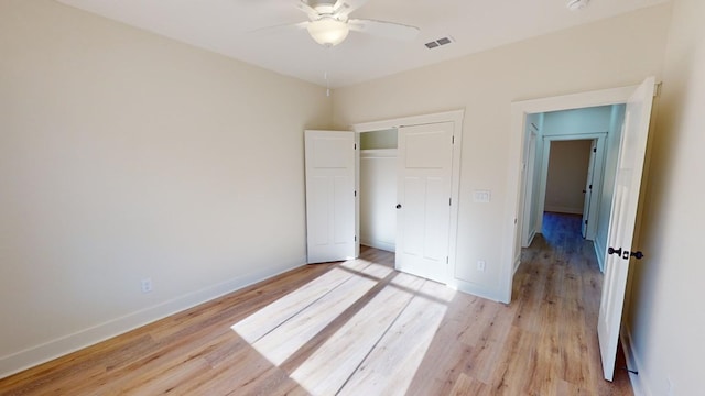 unfurnished bedroom featuring light hardwood / wood-style flooring, a closet, and ceiling fan