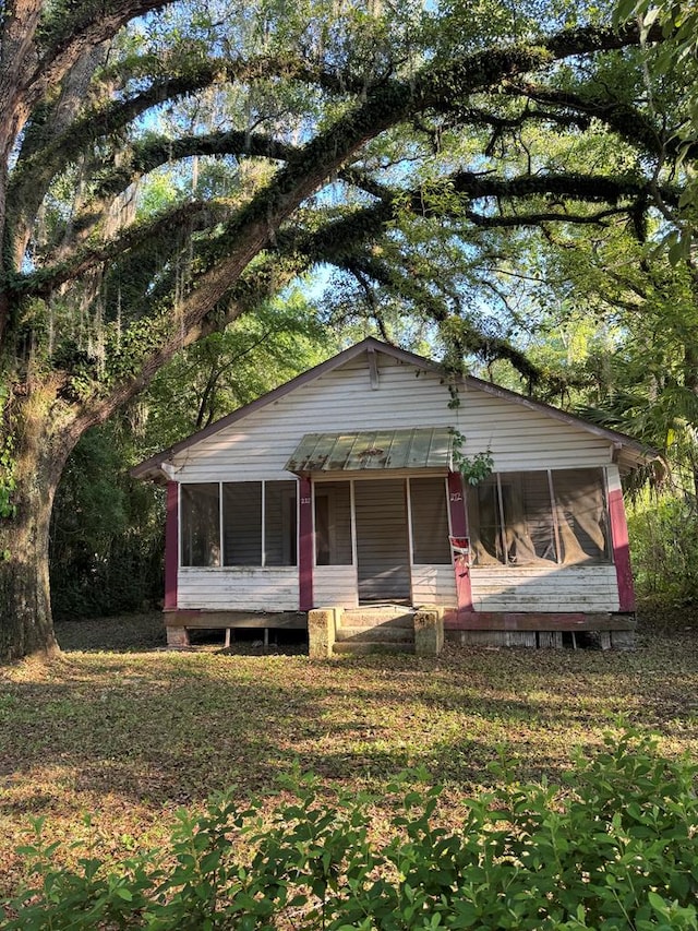view of front of home with a sunroom and metal roof
