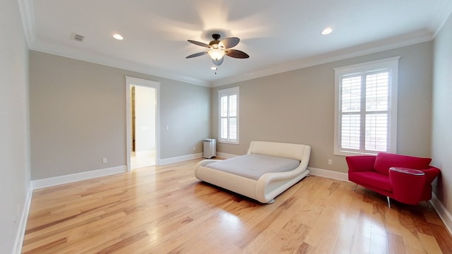 sitting room with ornamental molding, radiator, ceiling fan, and light wood-type flooring