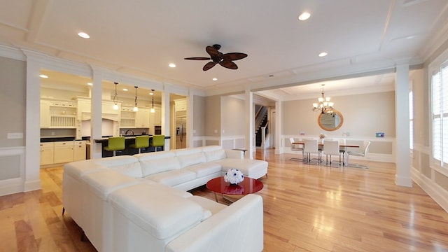 living room featuring crown molding, ceiling fan with notable chandelier, and light hardwood / wood-style floors