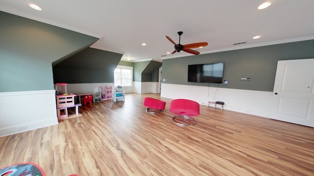 recreation room with crown molding, ceiling fan, and light hardwood / wood-style floors