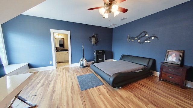 bedroom with ceiling fan, connected bathroom, and light wood-type flooring