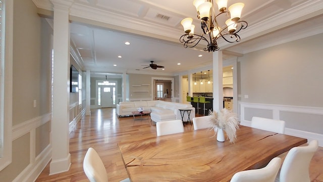 dining area with crown molding, ceiling fan with notable chandelier, and light hardwood / wood-style flooring