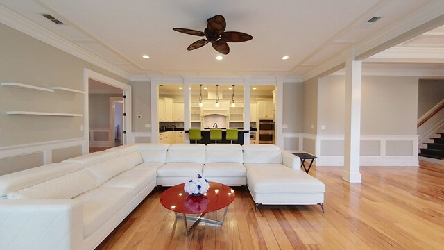 living room with ornamental molding, hardwood / wood-style floors, and ceiling fan