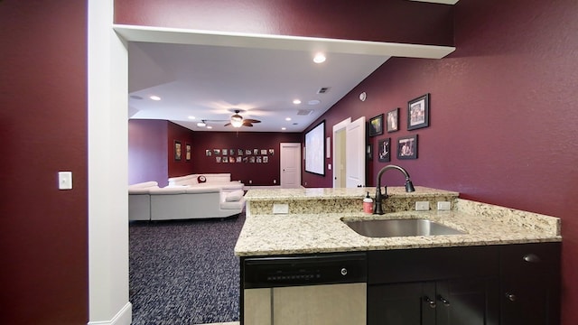 kitchen featuring ceiling fan, stainless steel dishwasher, light stone countertops, and sink