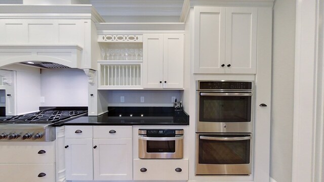 kitchen with ornamental molding, stainless steel appliances, and white cabinets