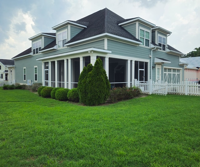 rear view of property featuring a yard and a sunroom