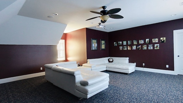 home theater room with ceiling fan and dark colored carpet