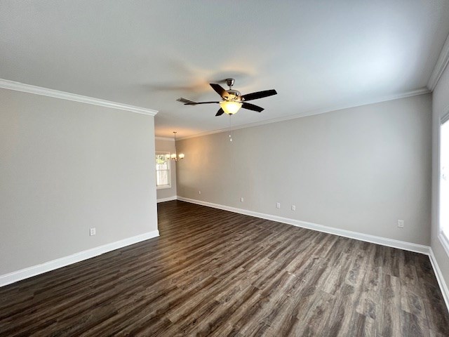 spare room with crown molding, dark wood-type flooring, and ceiling fan with notable chandelier