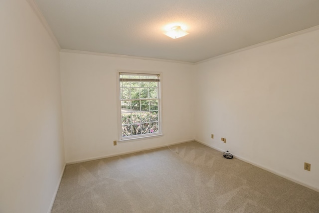 carpeted spare room with baseboards, a textured ceiling, and crown molding