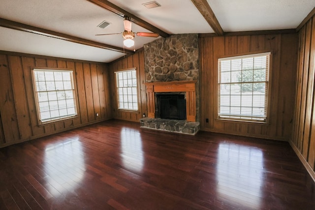 unfurnished living room with a ceiling fan, wood finished floors, visible vents, and a wealth of natural light
