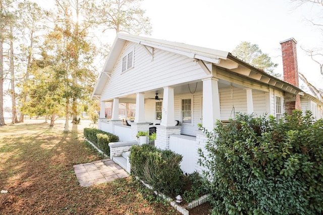 view of side of home with a porch and a chimney