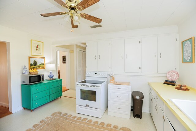 kitchen with electric range, visible vents, white cabinets, stainless steel microwave, and light countertops