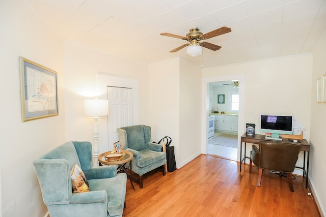 office area with wood finished floors, a ceiling fan, and baseboards