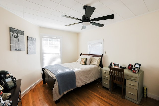 bedroom featuring dark wood-style floors, multiple windows, baseboards, and ornamental molding