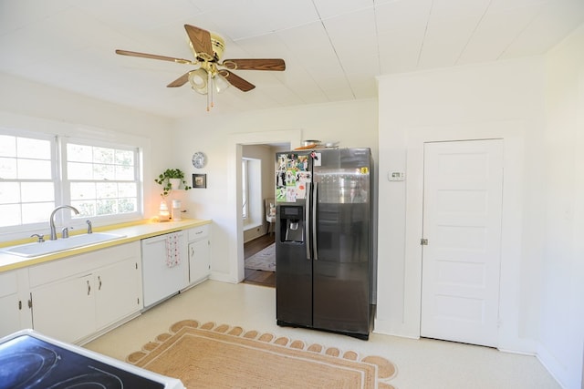 kitchen featuring white appliances, a ceiling fan, light countertops, white cabinetry, and a sink