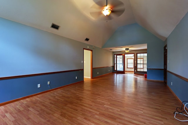 spare room featuring wood-type flooring, high vaulted ceiling, and ceiling fan