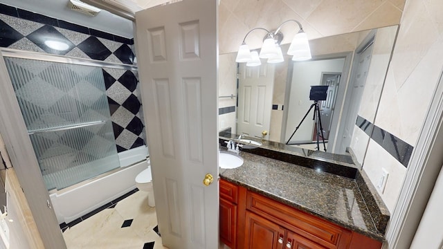 full bathroom with vanity, tile patterned flooring, combined bath / shower with glass door, and toilet