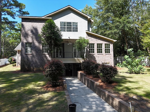 view of front facade featuring a balcony and a front yard