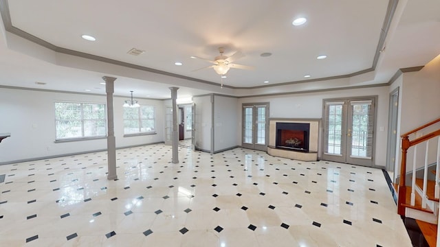 living room with decorative columns, ornamental molding, ceiling fan, and a tray ceiling