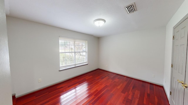 spare room featuring dark wood-type flooring