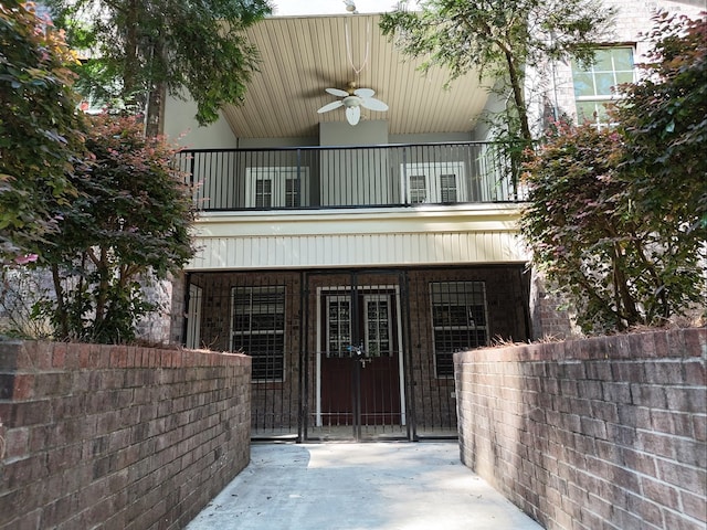 entrance to property featuring a balcony and ceiling fan