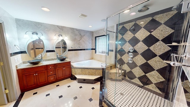 bathroom with tile patterned flooring, vanity, separate shower and tub, and tile walls