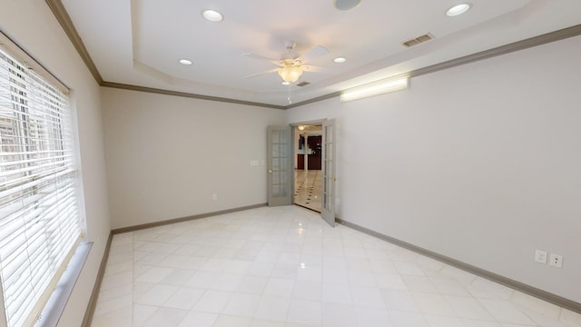 unfurnished room featuring ceiling fan, ornamental molding, and a tray ceiling