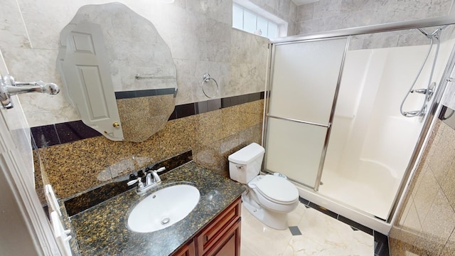 bathroom featuring tile walls, vanity, toilet, and walk in shower