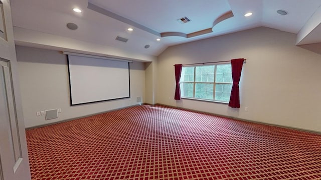 carpeted home theater with vaulted ceiling