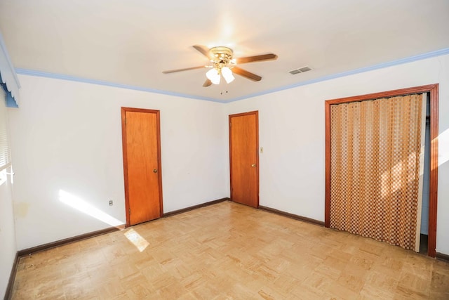 unfurnished bedroom featuring multiple closets, ceiling fan, ornamental molding, and light parquet floors