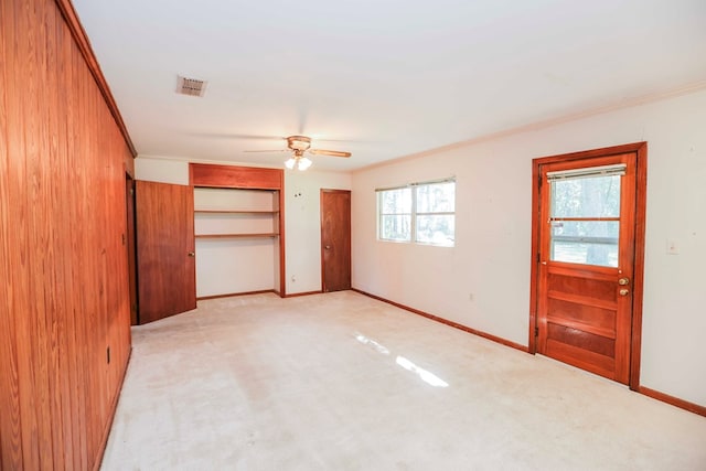 unfurnished bedroom featuring light carpet, ornamental molding, and ceiling fan