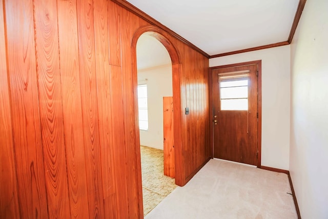 entryway featuring crown molding, light colored carpet, and a healthy amount of sunlight