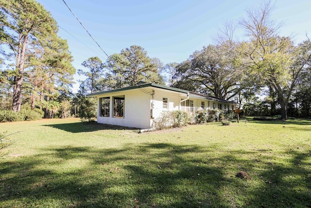 view of side of home with a lawn