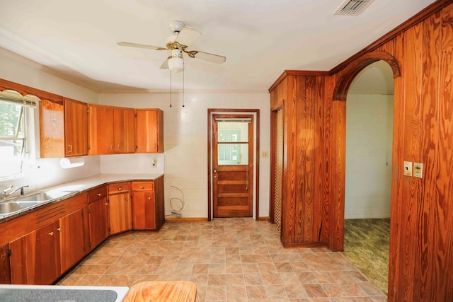 kitchen with ceiling fan, ornamental molding, and sink