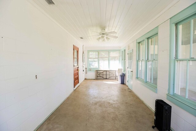 unfurnished sunroom with radiator, wood ceiling, and ceiling fan